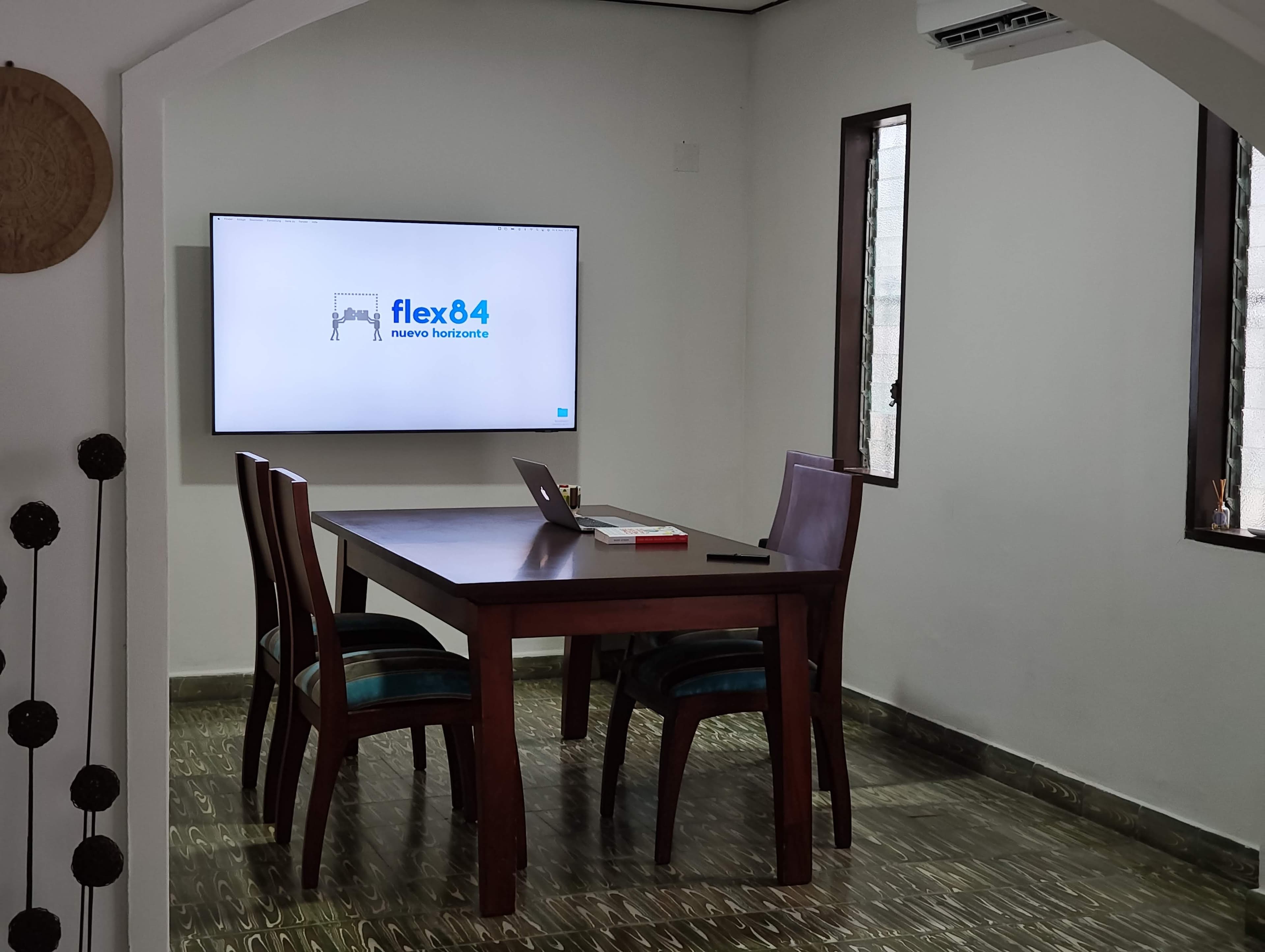 Sala principal con televisor mostrando el logo de Flex 84