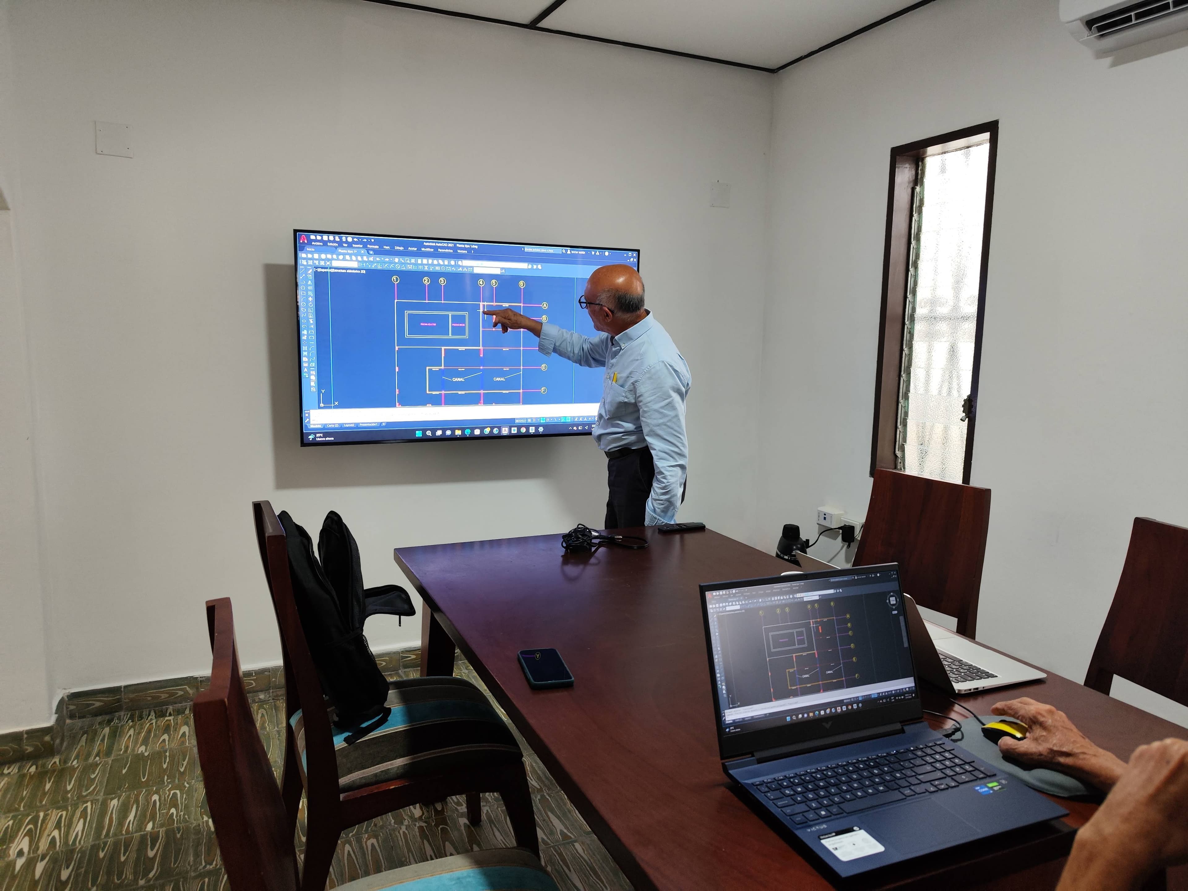 Presentación técnica con planos en pantalla