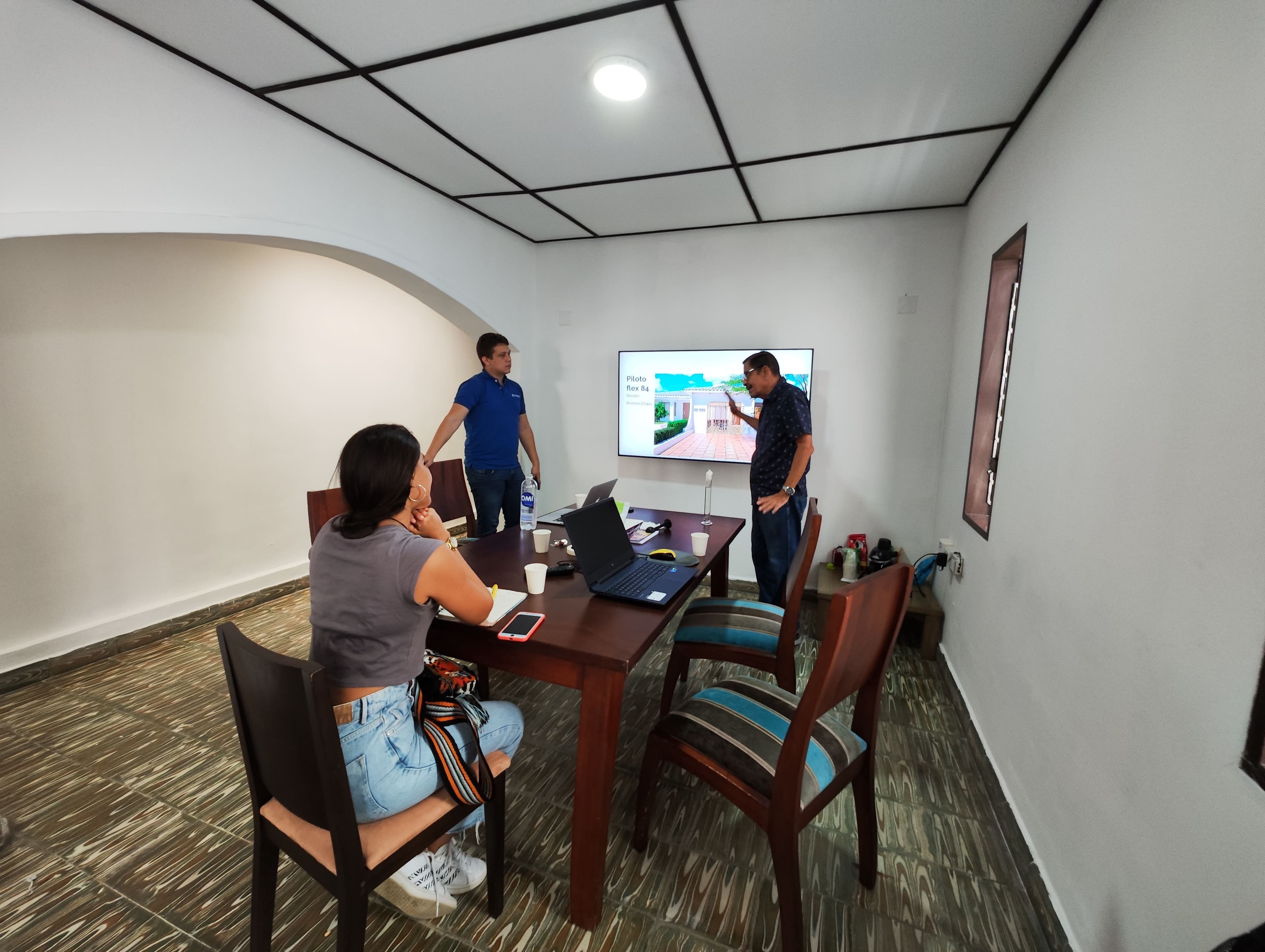 Equipo reunido frente a la pantalla durante presentación