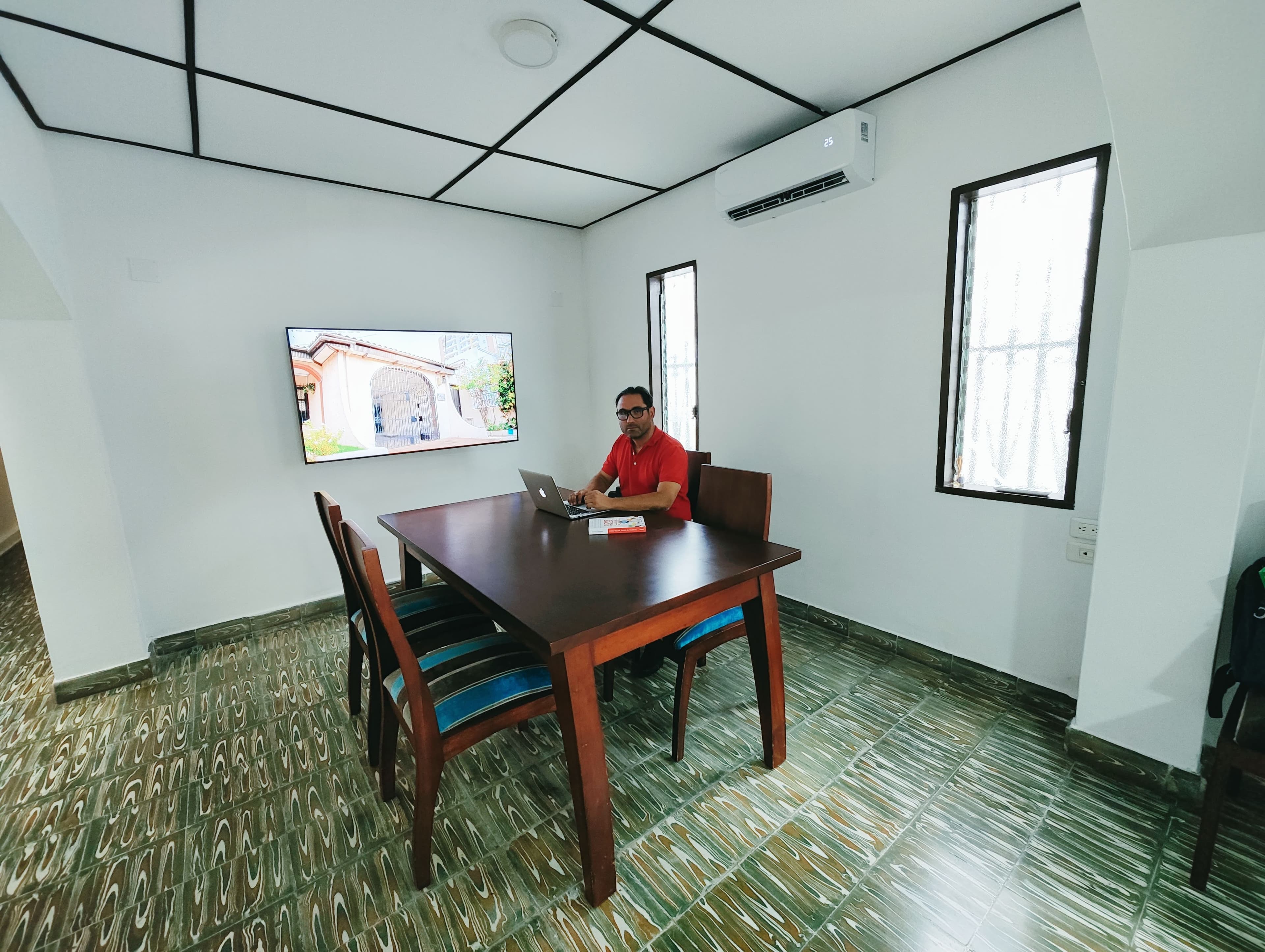 Trabajo individual con portátil y pantalla al fondo